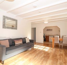 A living room with a sofa and dining area at Bracken Cottage St Tudy