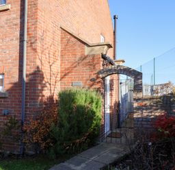 An outdoor view of a brick house entrance with a gate at Pond Farm View in Hinderwell