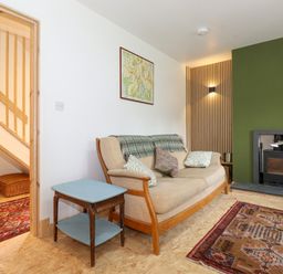 A living room with a sofa and a wood burning stove at Yamthwaite in Grizedale near Hawkshead