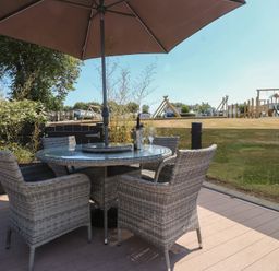 An outdoor area with a table and chairs under an umbrella at 97 Crugan Llanbedrog