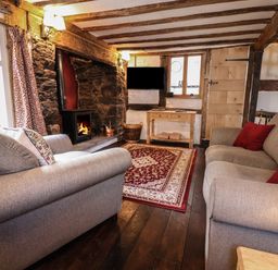 A living room with two sofas a carpet and a fireplace at 18 Church Street in Llangollen