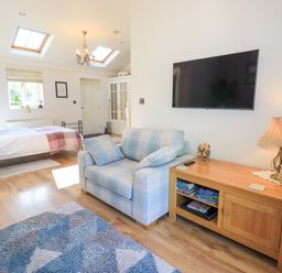 A bedroom with a bed and a couch at The Garden Suite at Fiddler Hall Barn, Newby Bridge