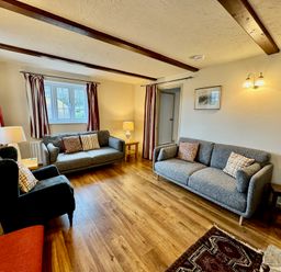 A living room with sofas and a lamp at Cajun Cottage in West Lulworth