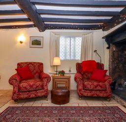 A living room with armchairs and a coffee table at Fox Hat Cottage in Chagford