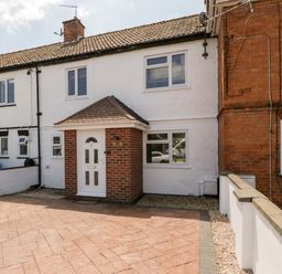 A front exterior view of a two-story terraced house with white walls and a small porch at Seacider in Burnham-On-Sea