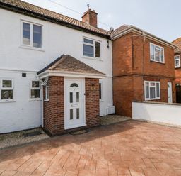 The front of a two-story house with a white door and brick porch at Seacider in Burnham-On-Sea