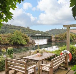 An outdoor area with a table and chairs at Island House in Golant near Tywardreath