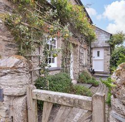 An entrance with a stone wall and gate at Island House in Golant near Tywardreath