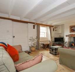 A living room with a sofa and fireplace at Island House in Golant near Tywardreath