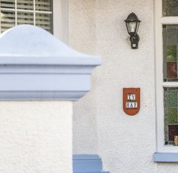 A house exterior with a window having stained glass panels and a sign with number 3 and Ty Haf plaque next to a black outdoor light fitting at 3 St Davids Place in Llandudno
