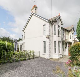 An exterior view of a semi detached house with a gravel driveway and garden at 24 Cadnant Park Conwy