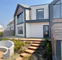 Exterior view of a modern two story house with stairs and garden at The Old Coastguard Lookout in Port Isaac