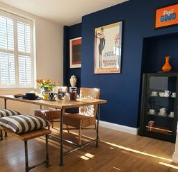 A dining room with a wooden table set for breakfast and wicker chairs at No.37 in Beverley