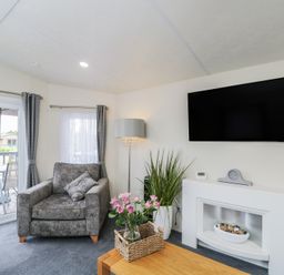 A living room with a sofa and television at The Cotswold Holiday Lodge Evesham