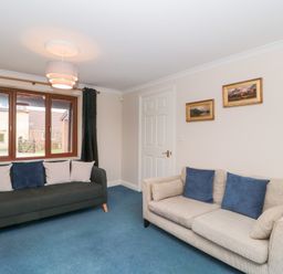 A living room with two sofas and framed pictures on wall at Morgan House in Middlezoy
