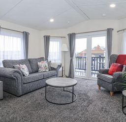 A living room with a sofa and armchair at Happy Daze Carnaby near Bridlington