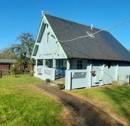 A light blue wooden house with a black roof on a grass lawn at Orchard Lodge in Hockworthy near Sampford Peverell Devon