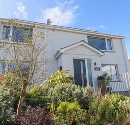 A two-story house with a garden and plants in front at Pickney House Killigarth near Polperro
