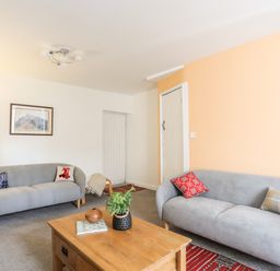 A living room with two gray sofas and a wooden coffee table at 9 Ty Du Road in Llanberis