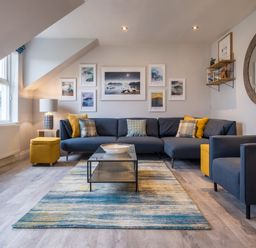 A living room with a sectional sofa pillows and a coffee table at Howe Keld 6 Second Floor in Keswick