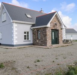 A house with a stone exterior and a gravel area at Tí Tom Nárta, Trabane near Lettermore, County Galway