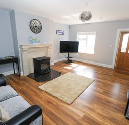 A living room with a television and fireplace at Tí Tom Nárta, Trabane near Lettermore, County Galway