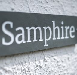 A close up of a sign with the text Samphire on a textured wall at Samphire in Rock