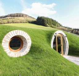 A hillside house with round window and arched door surrounded by grass at Nant y Garnedd Mallwyd near Dinas Mawddwy