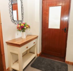 A hallway with a table and flowers at Summerseat in Kirkby Stephen