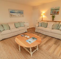A living room with two beige sofas and a wooden coffee table at 46 Castle Street Norham