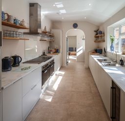 A kitchen with countertops on both sides appliances on the left and a window on the right at Spinnaker House in Scarborough