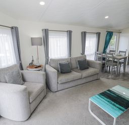 A living room with sofa and dining area at Serendipity