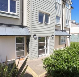 Exterior view of a residential building with windows doors metal awnings and bushes in front at 4 Pen Llanw Tides Reach in Rhosneigr