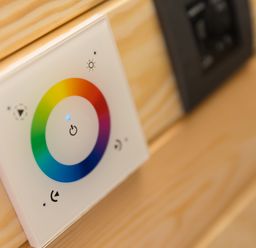 A wall-mounted color light switch panel on a wooden surface at Green Fields in St Buryan