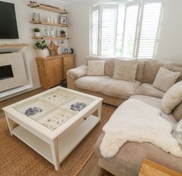 A living room with a sofa and a coffee table at Trelowen in St Issey near Padstow