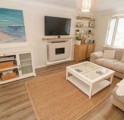 A living room with a sofa and a coffee table at Trelowen in St Issey near Padstow