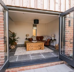 A living room with a brown leather sofa a wooden coffee table and a plant at Little Lugg in Cross Keys near Hereford