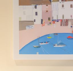 A framed abstract painting of boats in water with buildings in the background on a light wall