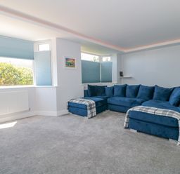 A living room with blue sectional sofa and gray carpet at Fisherman's Rest in Wyke Regis
