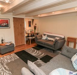 A living room with two grey sofas a patterned rug and a wooden sliding door at Stonewall Sandsend