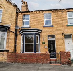 A brick terraced house with a black front door and bay window at 89 Caledonia Street in Scarborough