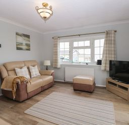 A living room with a sofa and television at Seaward in Trimingham