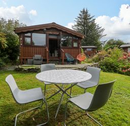 A cabin with seating area and table in the garden at Babbling Brook near Blaenau Ffestiniog
