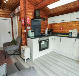 A kitchen with appliances and seating area at Babbling Brook in Bron Aber near Blaenau Ffestiniog