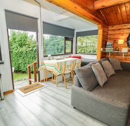 A snug area with a couch and dining table at Babbling Brook in Bron Aber near Blaenau Ffestiniog