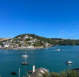 A coastal town with buildings and boats on the water at Upper Tremorvah in Dartmouth