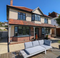 A two story house with a patio sofa and plants outside at Greenbank in Woolacombe