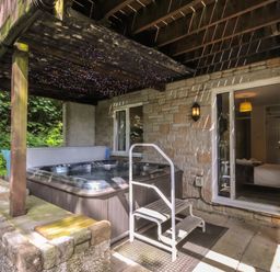A hot tub with steps on a patio at Hideaway Cottage, St Ann's Chapel, Cornwall