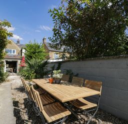 A garden with a dining table and chairs at Mallards Bourton-On-The-Water