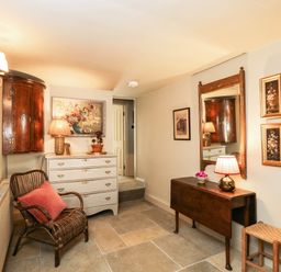 A hallway with a chest of drawers and a mirror at Mallards in Bourton-On-The-Water